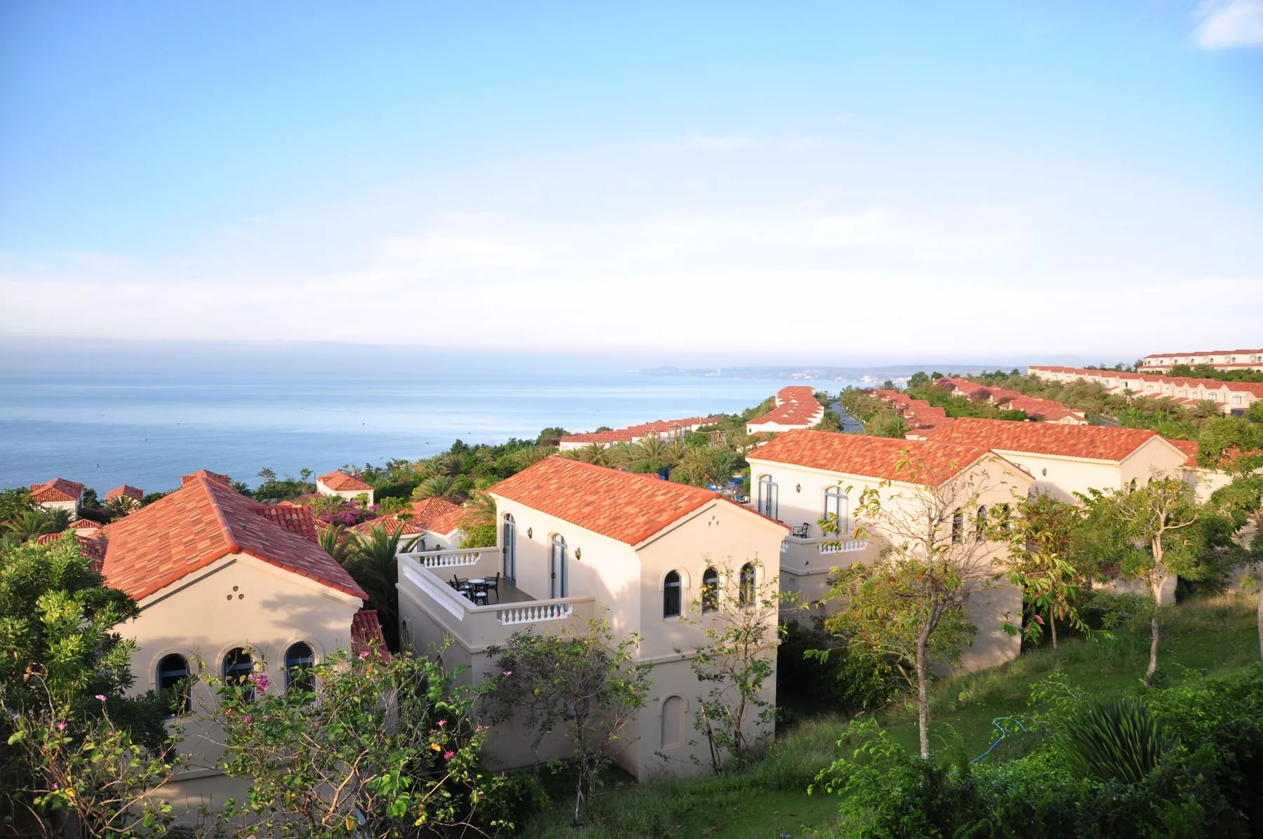 Σπίτια με κεραμοσκεπές ανάμεσα στα δέντρα, πάνω από τη θάλασσα