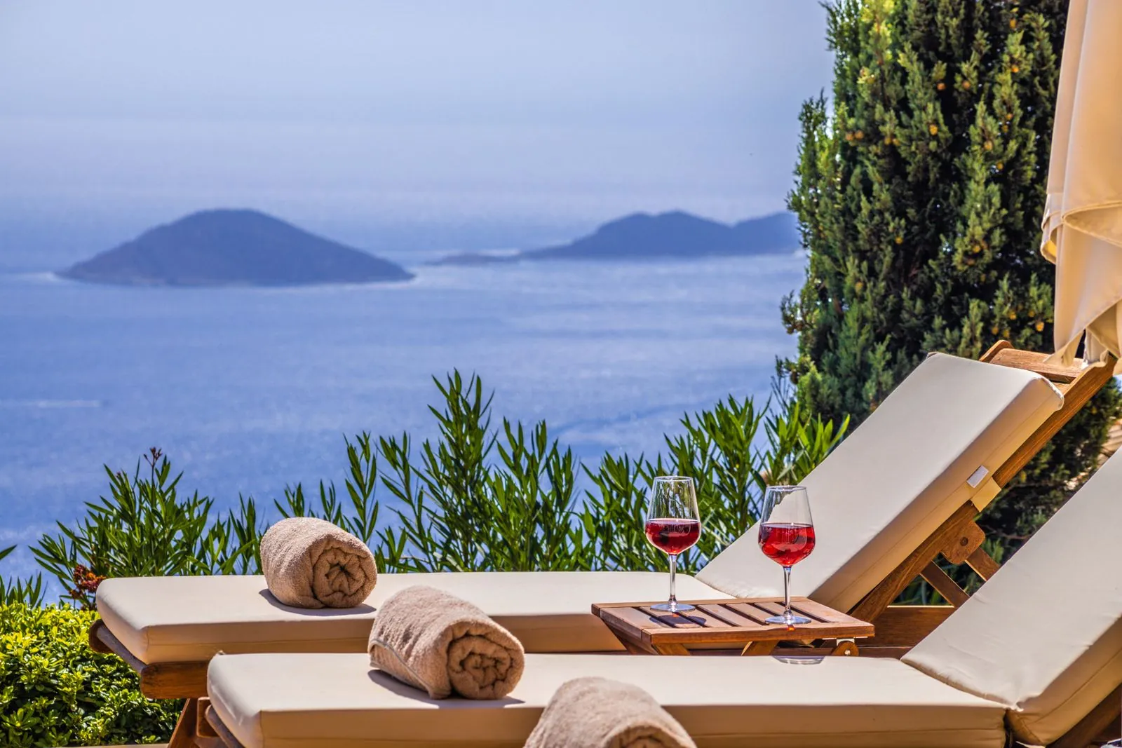 Δύο ξαπλώστρες και δύο ποτήρια κρασί μπροστά στη θάλασσα